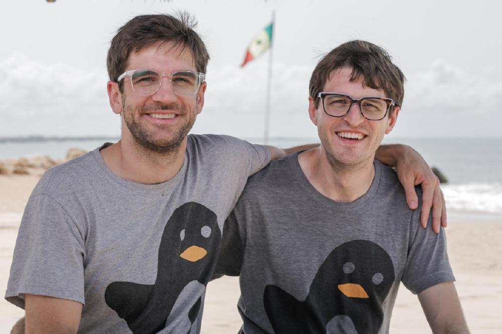 Drew and Lincoln at a beach, with the flag of Senegal behind them